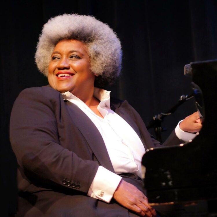 Tammy Hall playing a piano on stage