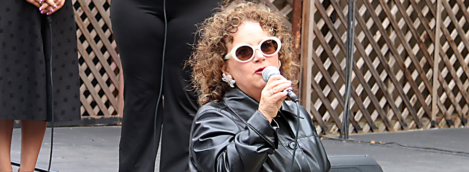 Janice Perl performing on an outside stage