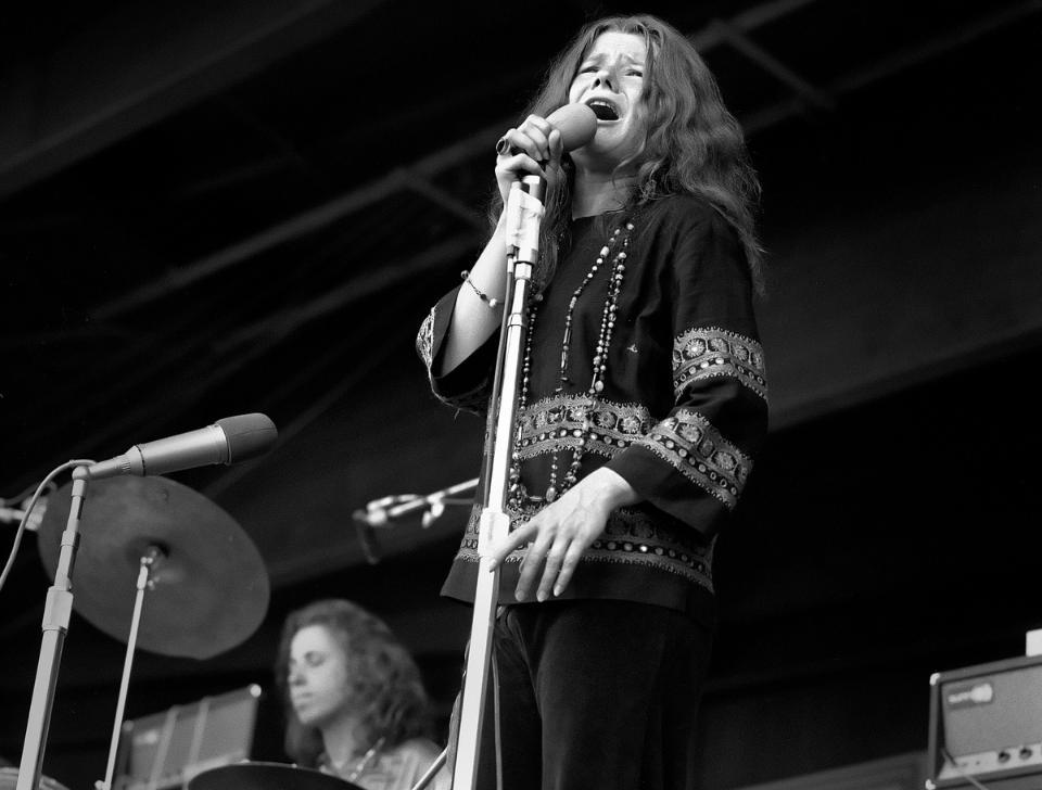 Janis Japlin performing on stage, in black and white.