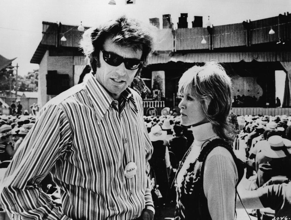 Clint Eastwood and Jessica Walter standing behind the audience at Monterey Jazz Festival in 1970, in black and white