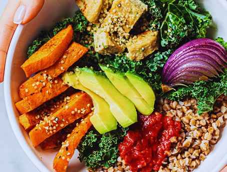Bowl filled with vegetables including avocado, red onion, and kale