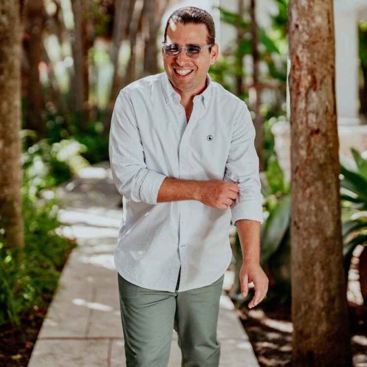 Alfredo Rodriguez walking on a white brick path outside