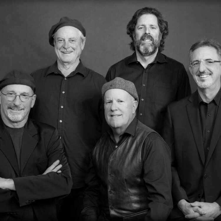 Members of Along Came Betty standing in front of plain background in black and white