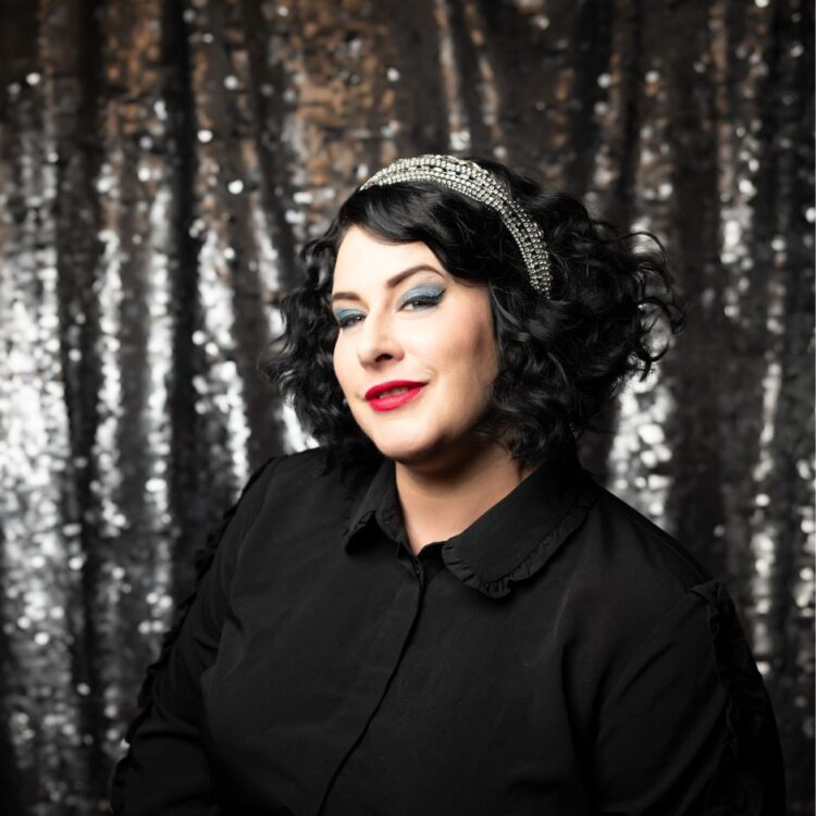 Davina Sowers in front of an out of focus glittery grey backdrop