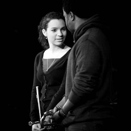 Elena Pinderhughes and Ambrose Akinmusire facing eachother in front of a black background in black and white.