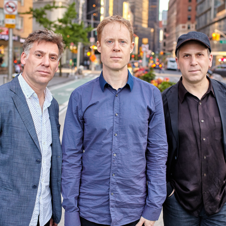 Members of the Goldings Bernstein Stewart Trio standing in an out of focus city street