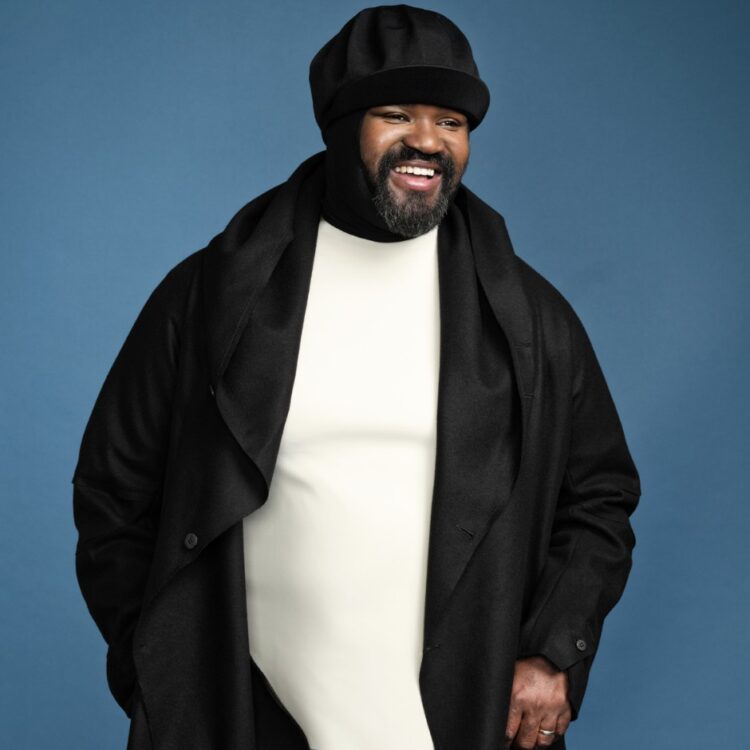 Gregory Porter standing in front of a sky blue background