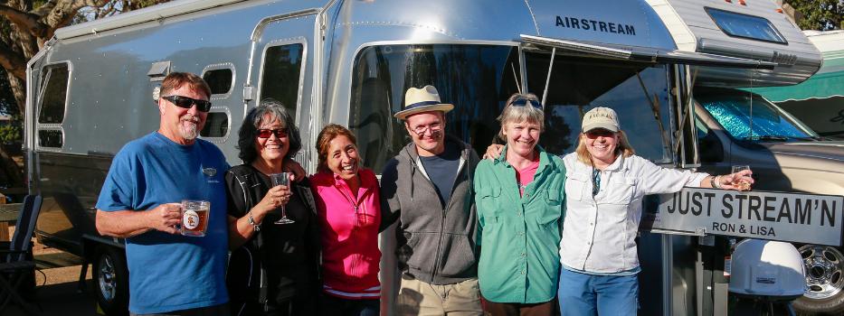 6 people standing in front of an Airstream RV