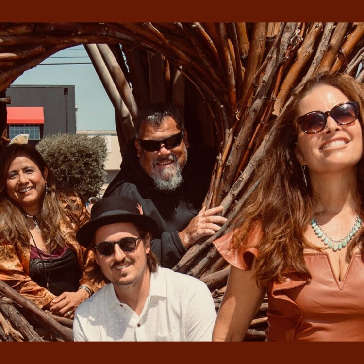 Members of River Voices standing outside with a wooden branch structure between them
