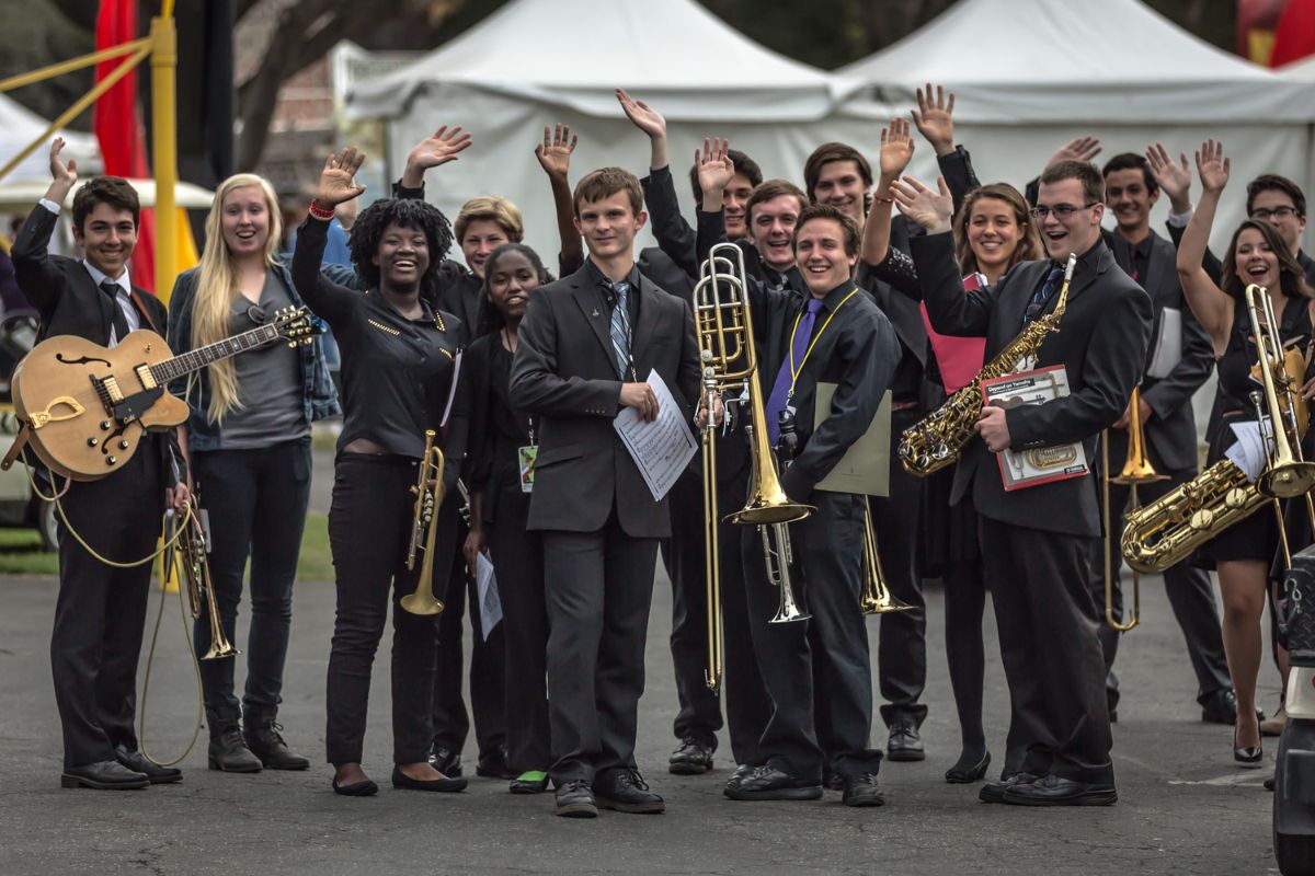 Group of musicians holding their instruments and waving
