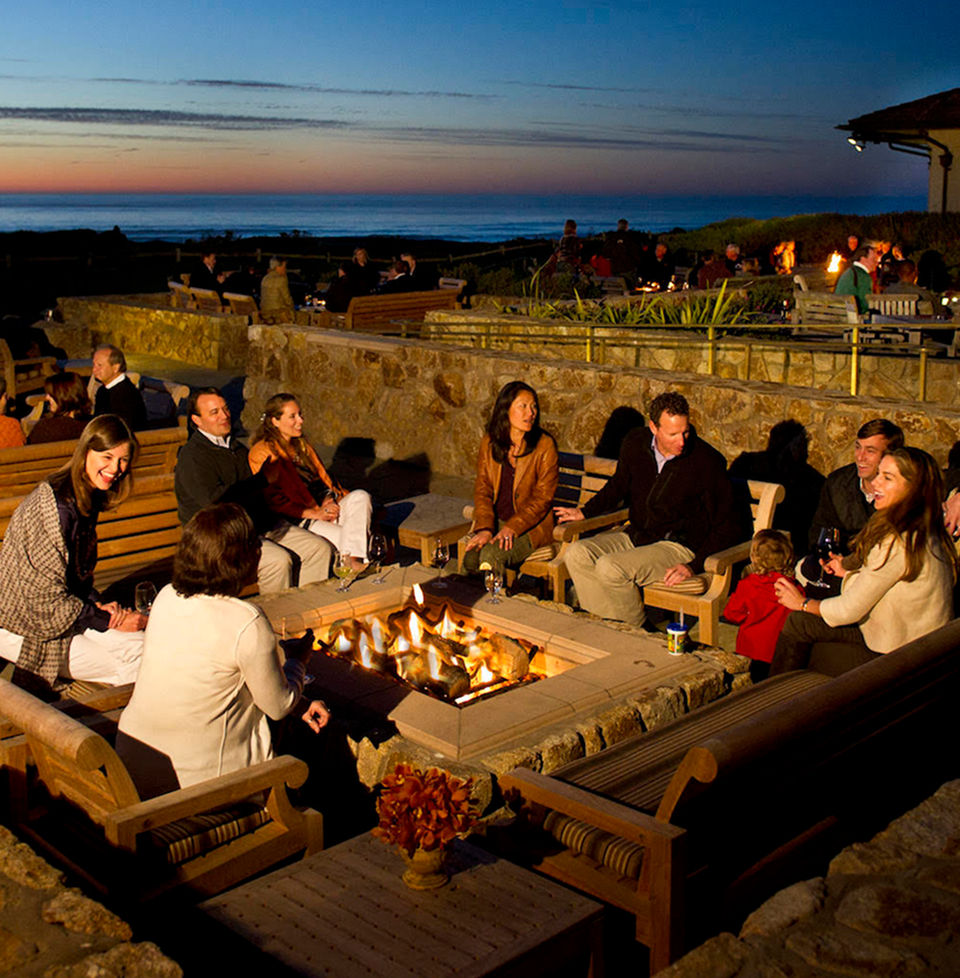 People sitting around a fire pit at The Inn at Spanish Bay