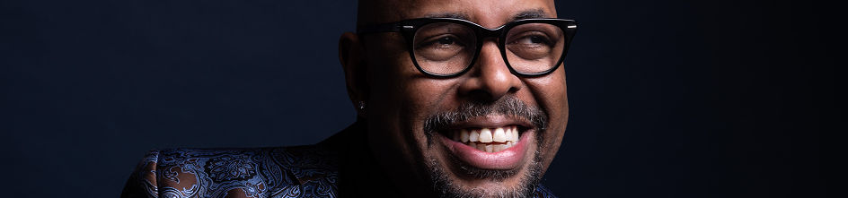 Close up of Christian McBride in front of a dark blue grey background