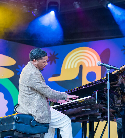 Christian Sands performing piano on stage