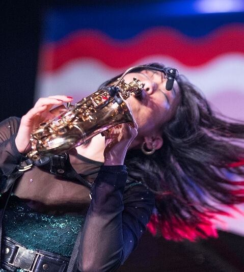 Grace Kelly performing saxophone on stage