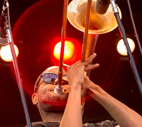 Trombone Shorty performing trombone on stage