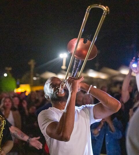 Trombone Shorty playing trombone in a crowd