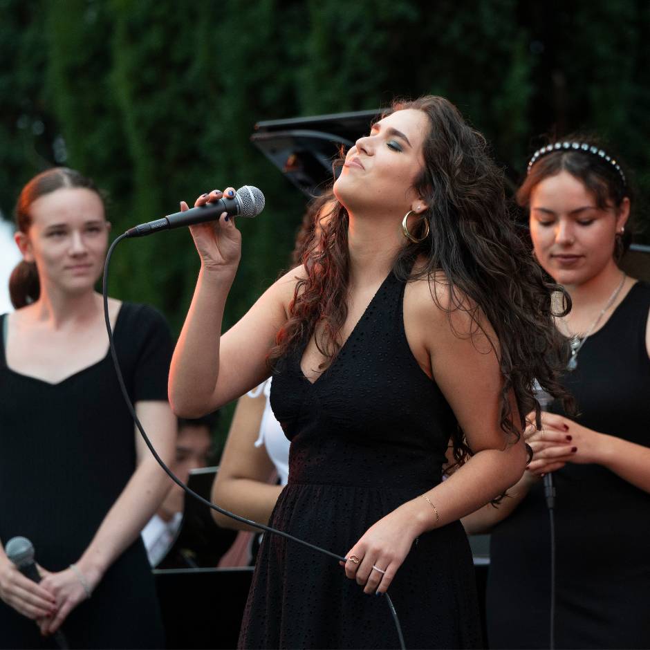 Three women singing on a stage