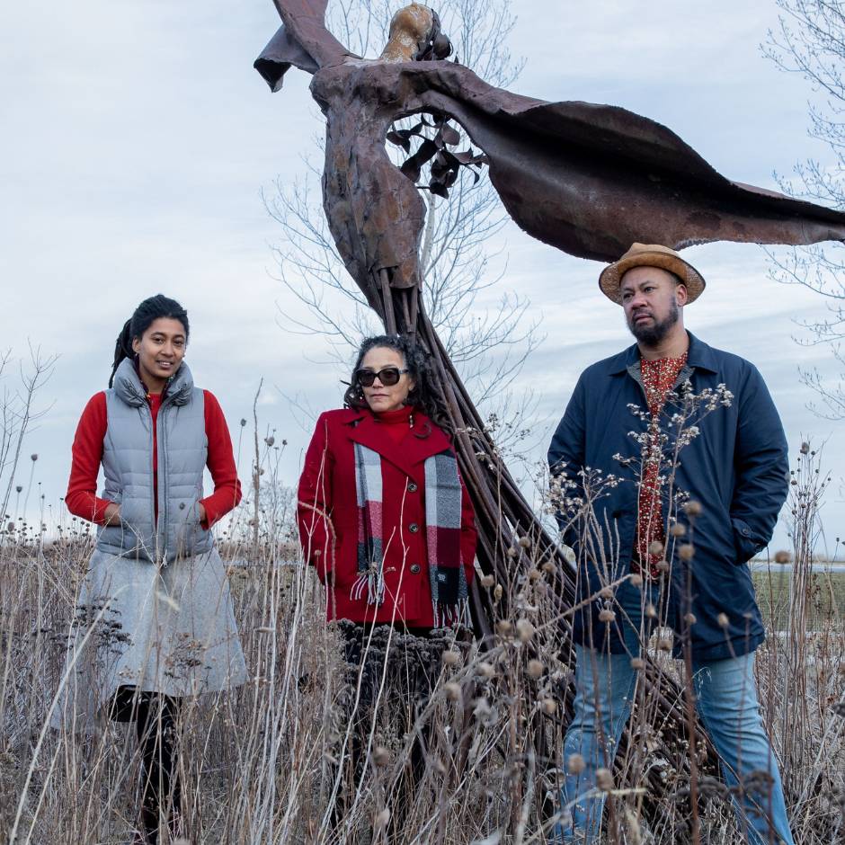 Three people standing in a field
