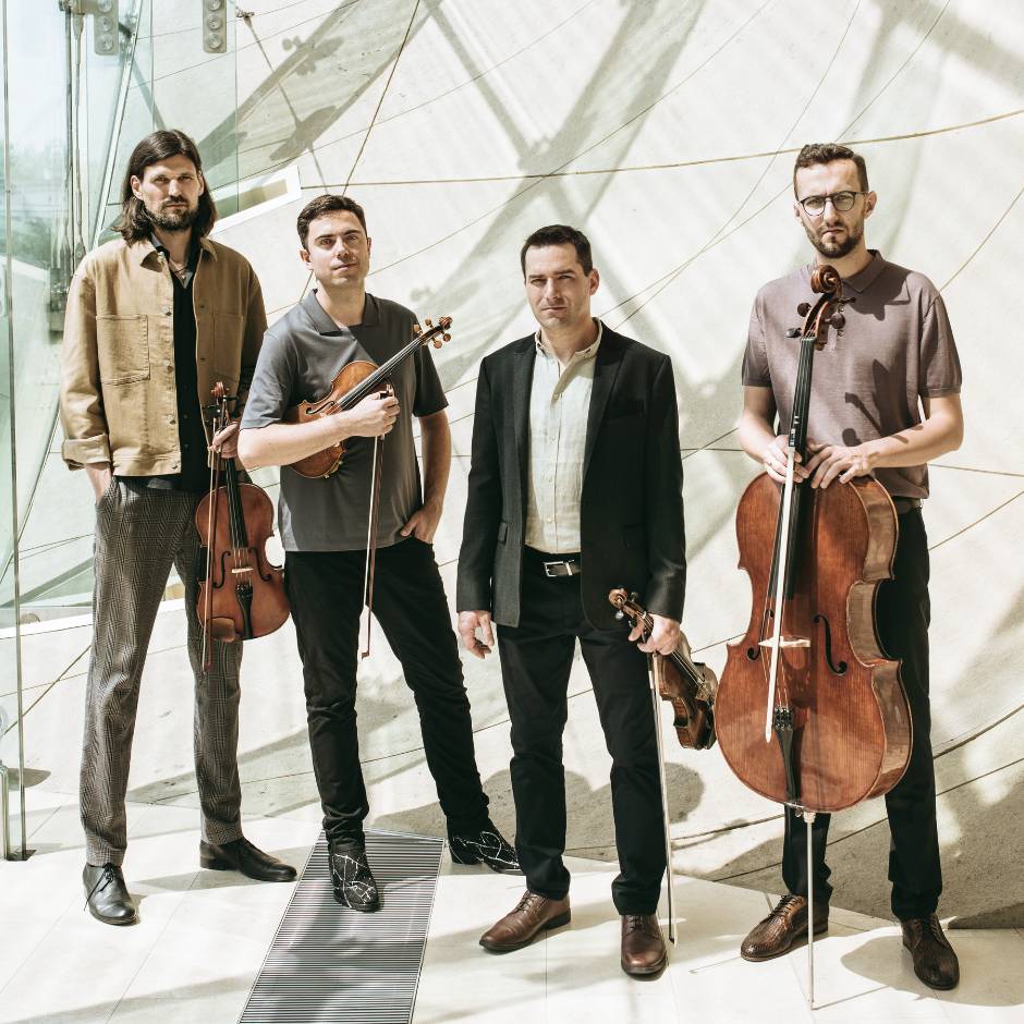 Four men standing holding insruments