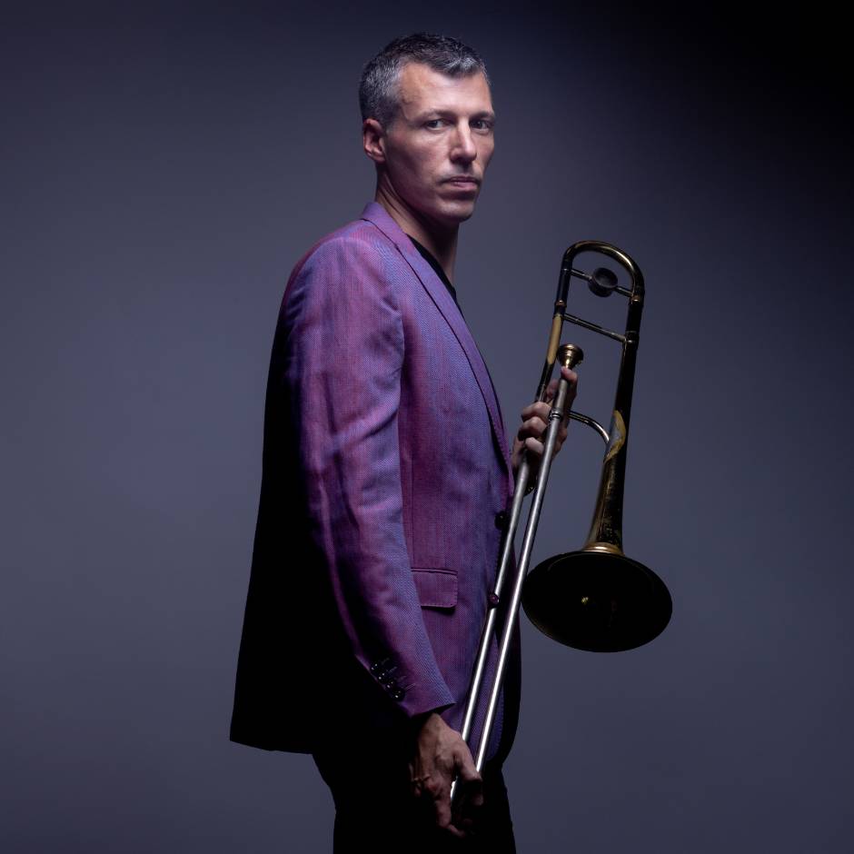 A person standing with a trombone
