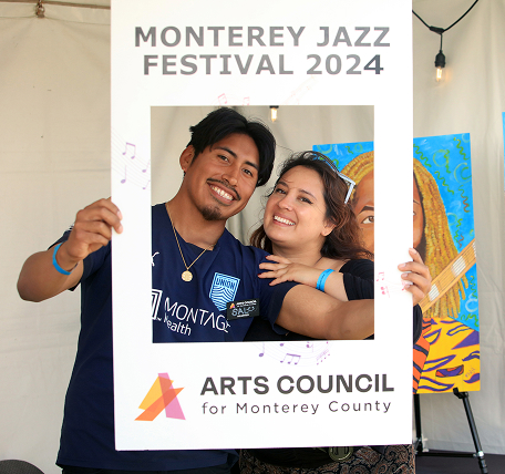 Two people smiling holding a physical picture frame.